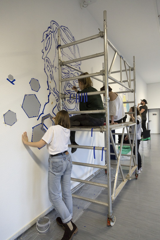 Studierende bei der Arbeit an einem Wandbild