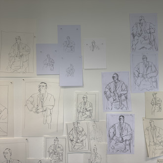 abstrahierte Zeichnungen einer sitzenden Person, an die Wand gepinnt