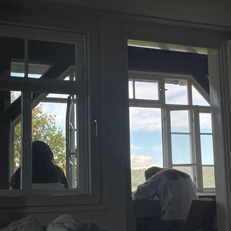 Studierende zeichnen vor einem Fenster