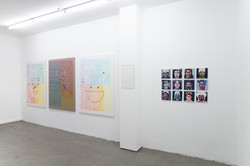 Ausstellungsansicht im Superraum Dortmund: links drei großformatige, abstrakte Arbeiten auf Papier, rechts eine rasterförmig gehängte Serie kleiner Porträtbilder an weißer Wand, Ausstellung TPLI III.