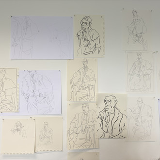 abstrahierte Zeichnungen einer sitzenden Person, an die Wand gepinnt