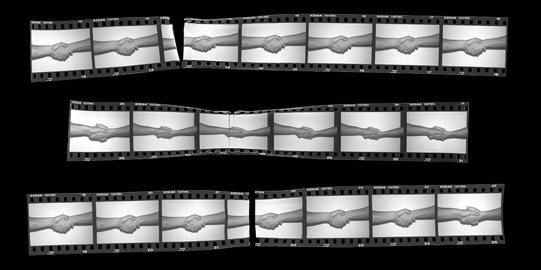 Arbeitsbereich Fotografie Zertrennter Kleinbildstreifen mit dem Motiv eines Handschlags