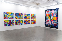 Eckansicht des Ausstellungsraums Superraum Dortmund: links acht farbintensive, abstrakte Gemälde in zwei Reihen, rechts ein großformatiges textiles Wandobjekt, Ausstellung TPLI III.