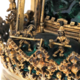 Detail einer vergoldeten Skulptur mit kleinen Figuren, die mit Hämmern arbeiten