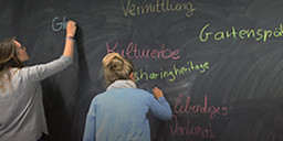 Studierende beim Arbeiten an einer Tafel