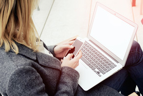 A woman has a laptop on her lap